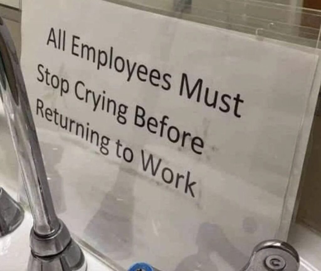 A sign reading "all employees must stop crying before returning to work" displayed at a workplace.