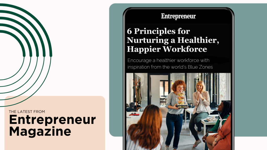 Smartphone displaying an article from entrepreneur magazine titled "6 principles for nurturing a healthier, happier workforce" beside an image of coworkers enjoying a break together.