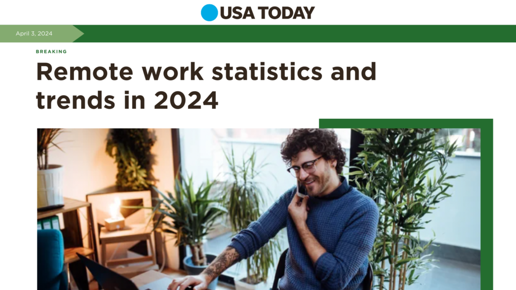 Smiling man with glasses working on a laptop in a plant-filled home office, featured in a usa today article about 2024 remote work trends.