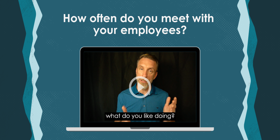 A man in a video embedded on a laptop screen speaks while the text "How often do you meet with your employees?" is displayed at the top and captions at the bottom read, "what do you like doing?.